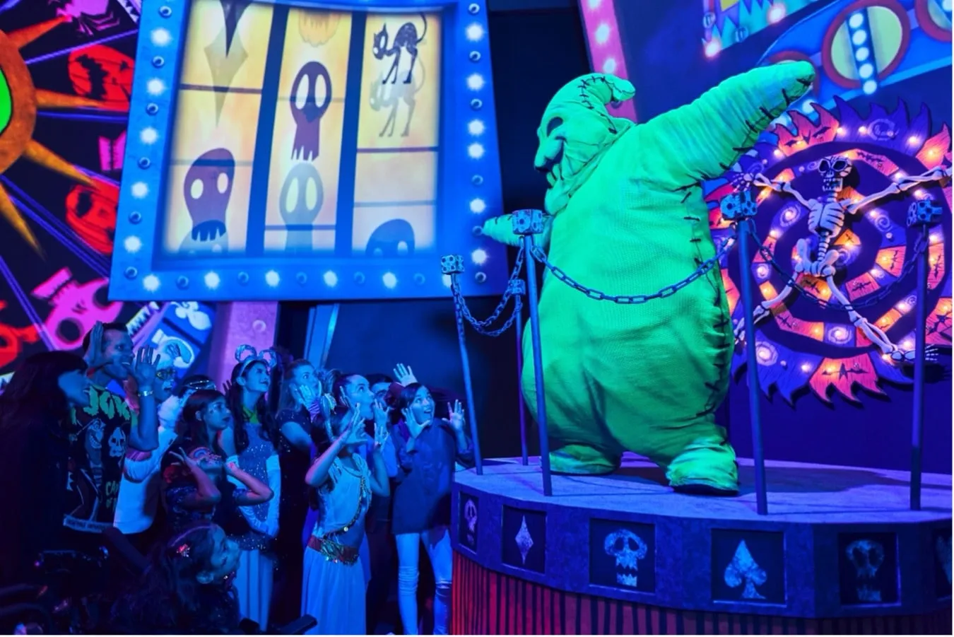 a group of people watching a green creature on a stage