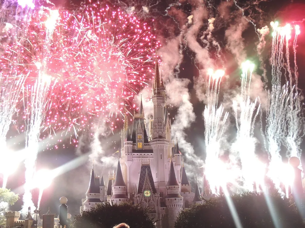Fireworks bursting over Cinderella Castle at night
