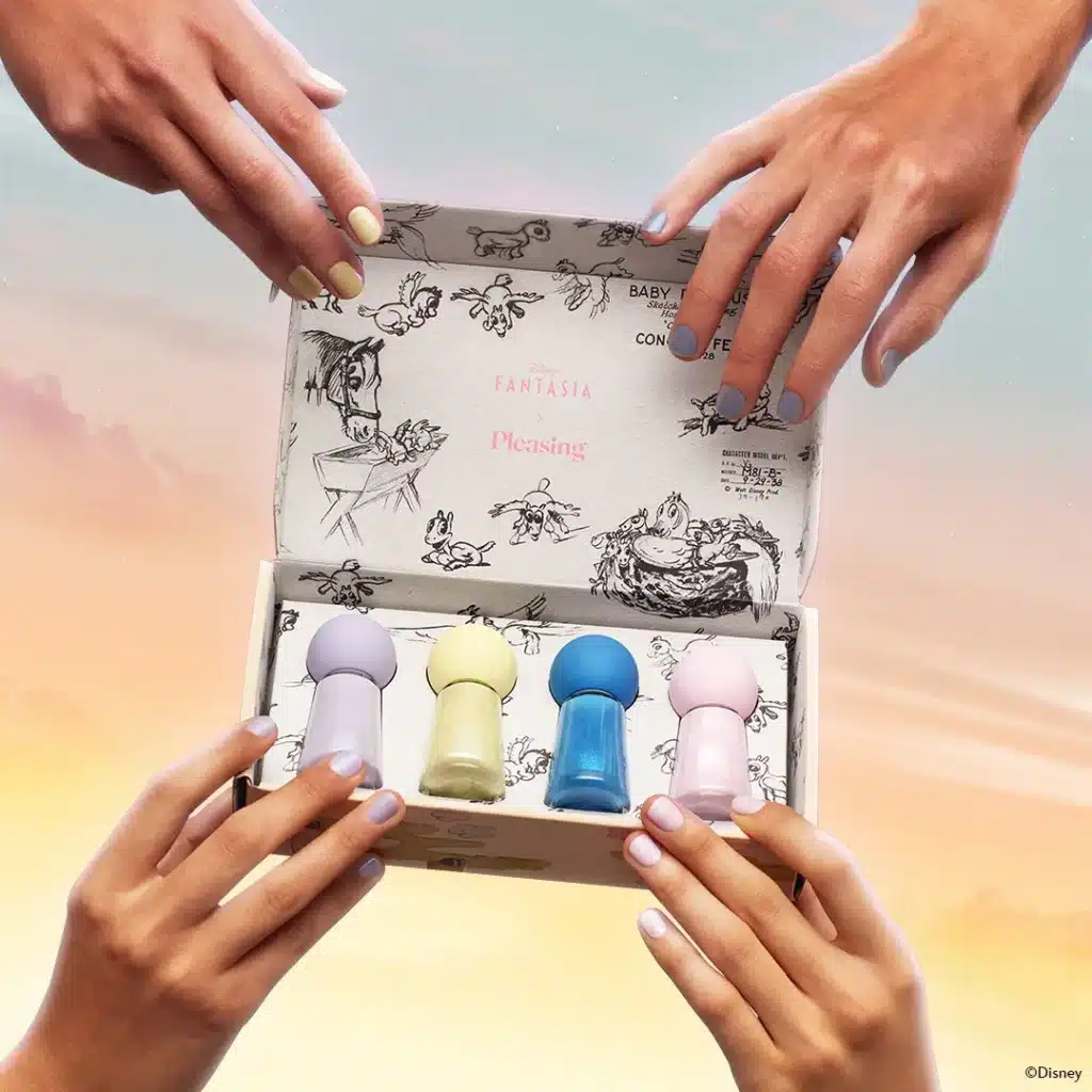 a group of hands holding a box with small objects